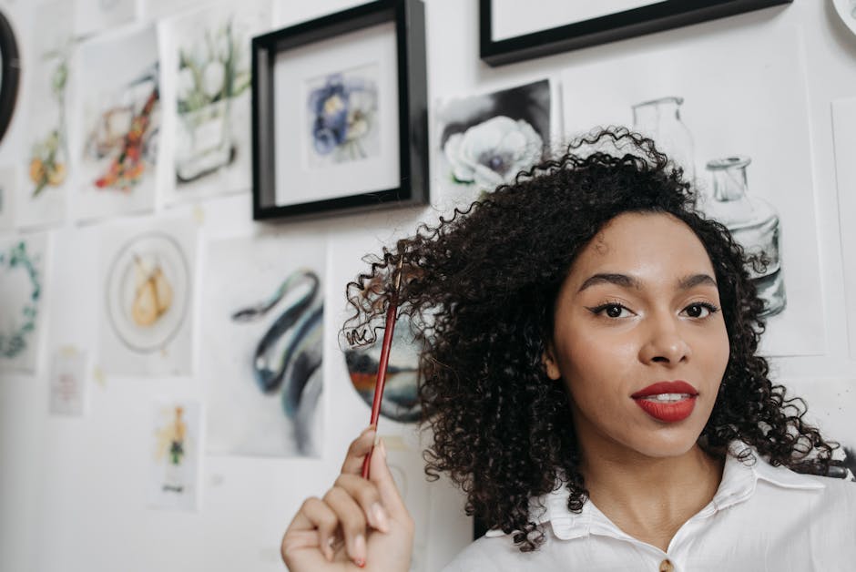 A woman holding a paintbrush in an art studio surrounded by watercolor paintings. Inspiring and creative atmosphere.