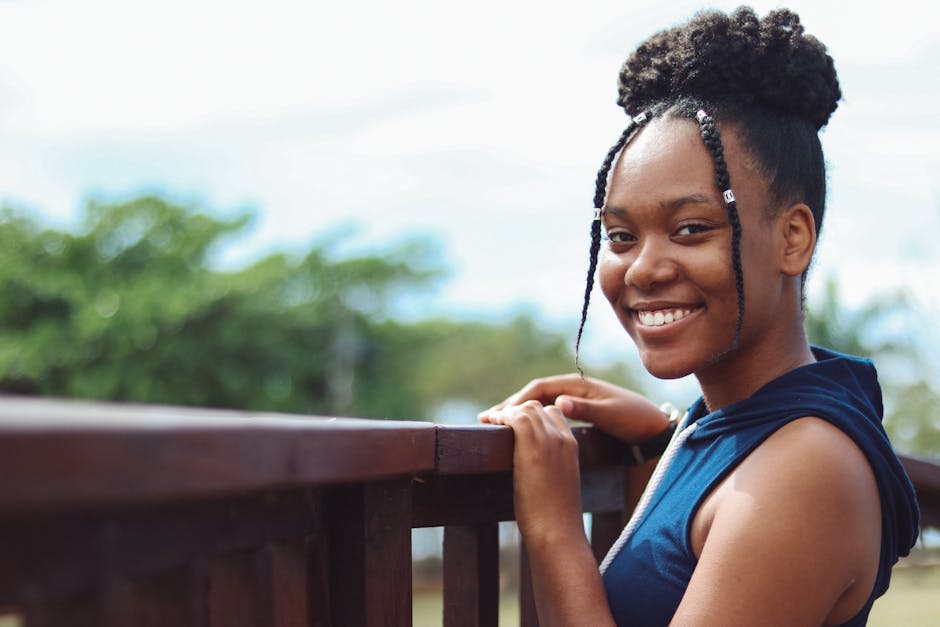 Portrait of a cheerful young woman smiling outdoors on a sunny day.