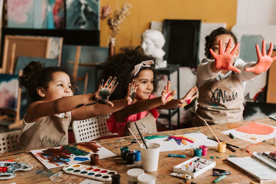 Three children having fun painting with hands in an art studio. Vibrant and playful atmosphere.
