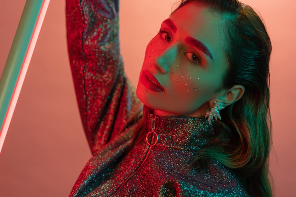 Stylish portrait of a woman in glittery outfit under vibrant neon lighting. Fashion-forward and creative.