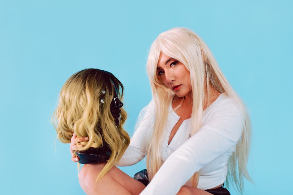 Stylish woman holding a mannequin head with a wig against a vibrant blue background.