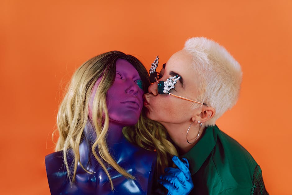 A unique portrait featuring a person interacting with a colorful mannequin on a vibrant orange backdrop.
