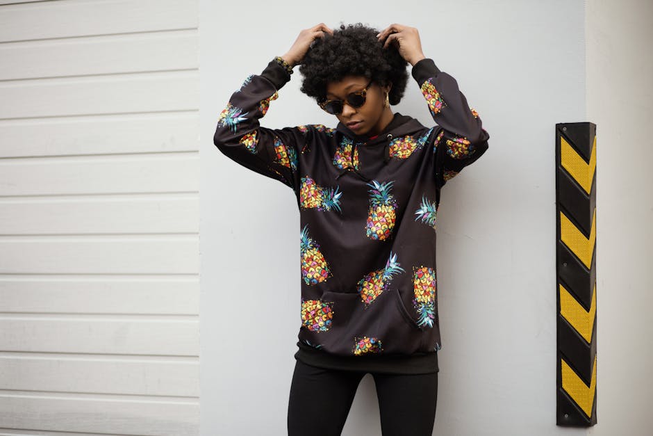 Stylish woman wearing a pineapple print hoodie poses outdoors, exuding modern fashion sense.