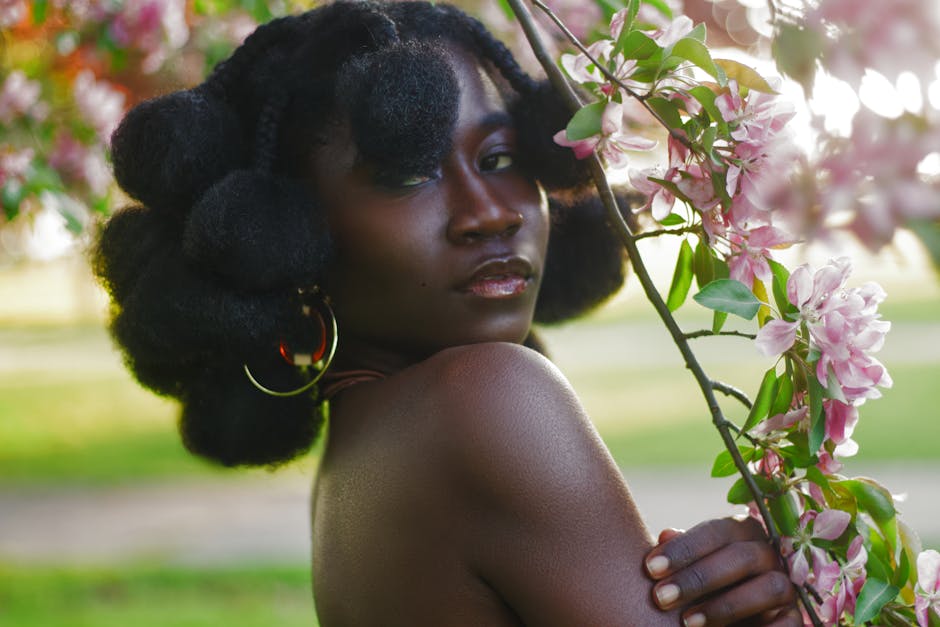 Beautiful portrait of an African woman posing with pink blossoms, capturing the essence of summer.