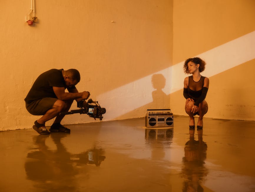 A photographer captures a young woman posing with a boom box in an industrial setting.