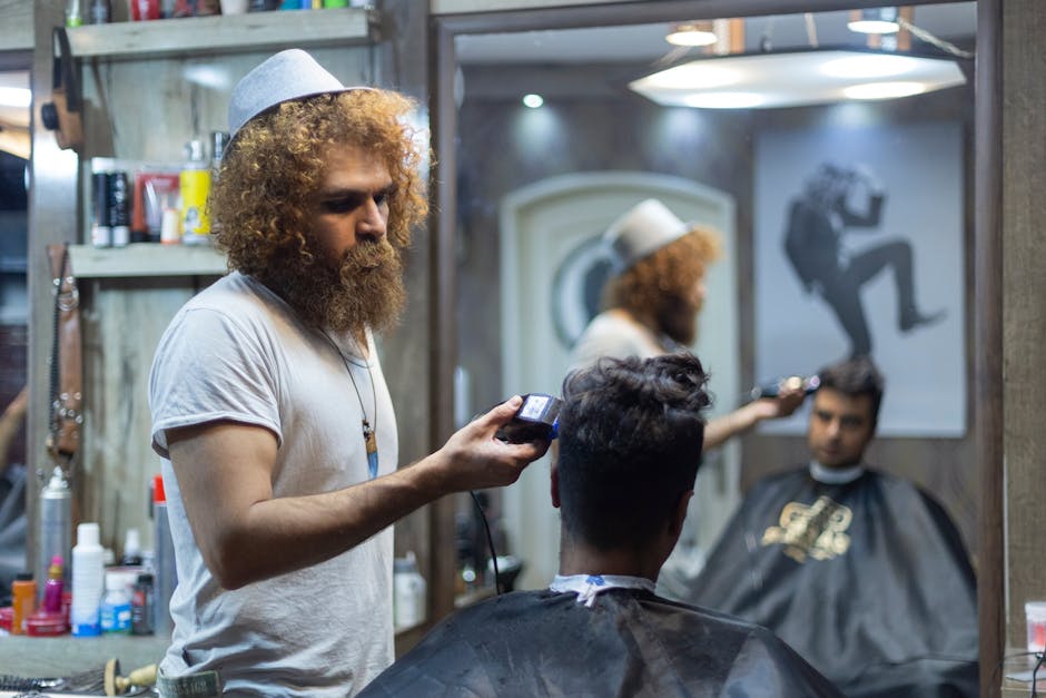 Barber trims customer's hair in a contemporary barbershop with mirrors and stylish decor.