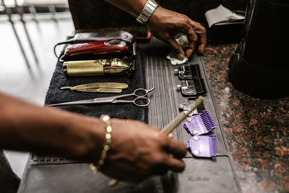 High-angle shot of barber tools on a work mat, including scissors and clippers.