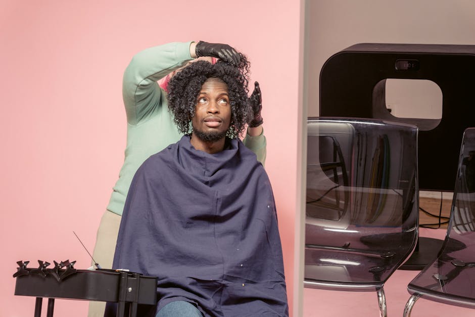 A professional hairdresser styling a client's curly hair in a modern salon setting.