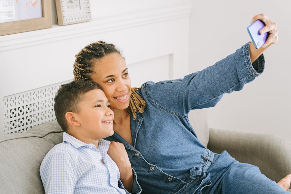 Mother and son enjoying a joyful moment together taking a selfie on the sofa.