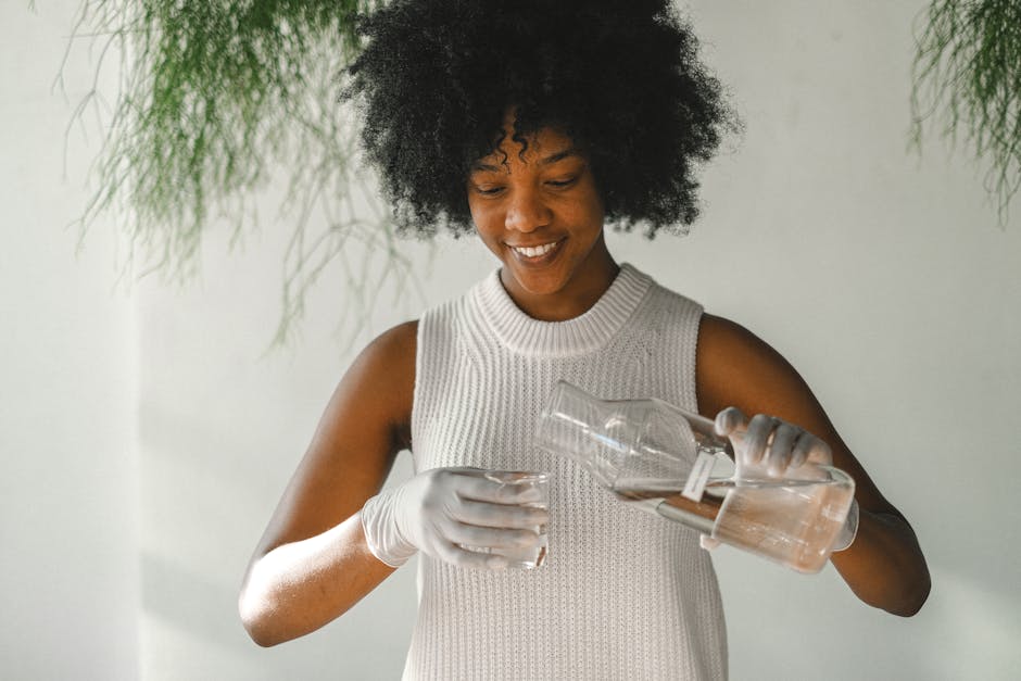 Afro-haired woman pouring essential oils indoors with a smile. Aromatherapy and natural wellness theme.