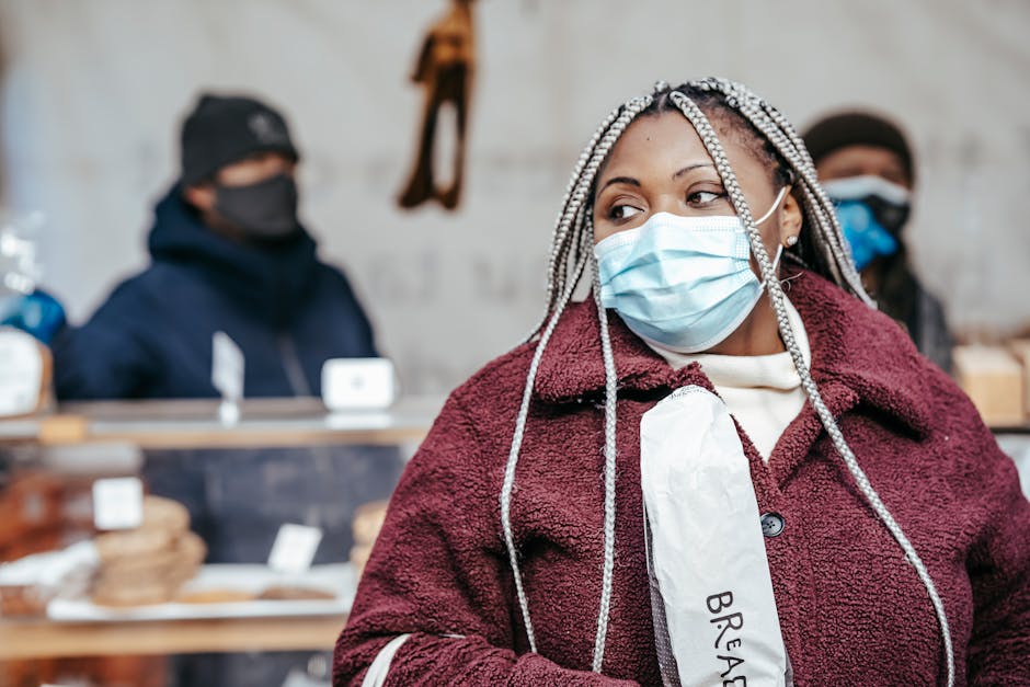Woman wearing a mask shops for bread at an outdoor market stall during the pandemic.